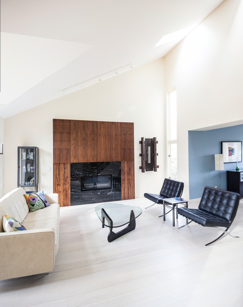 На фото: открытая, парадная гостиная комната среднего размера в современном стиле с синими стенами, светлым паркетным полом, стандартным камином и фасадом камина из дерева без телевизора с