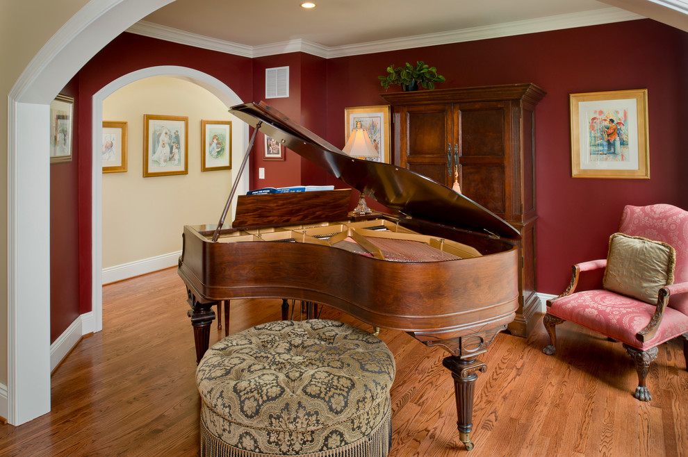 Foto de salón con rincón musical cerrado tradicional de tamaño medio sin chimenea y televisor con paredes rojas, suelo de madera en tonos medios y suelo marrón