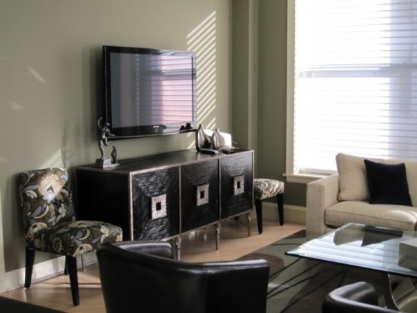 Idée de décoration pour un salon design de taille moyenne et ouvert avec un téléviseur fixé au mur, un mur gris, parquet clair et un sol marron.