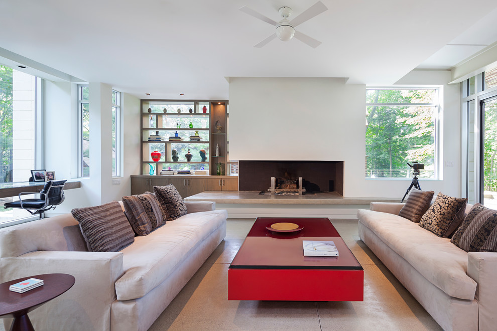 Large minimalist open concept concrete floor living room photo in Grand Rapids with white walls, a two-sided fireplace and a plaster fireplace