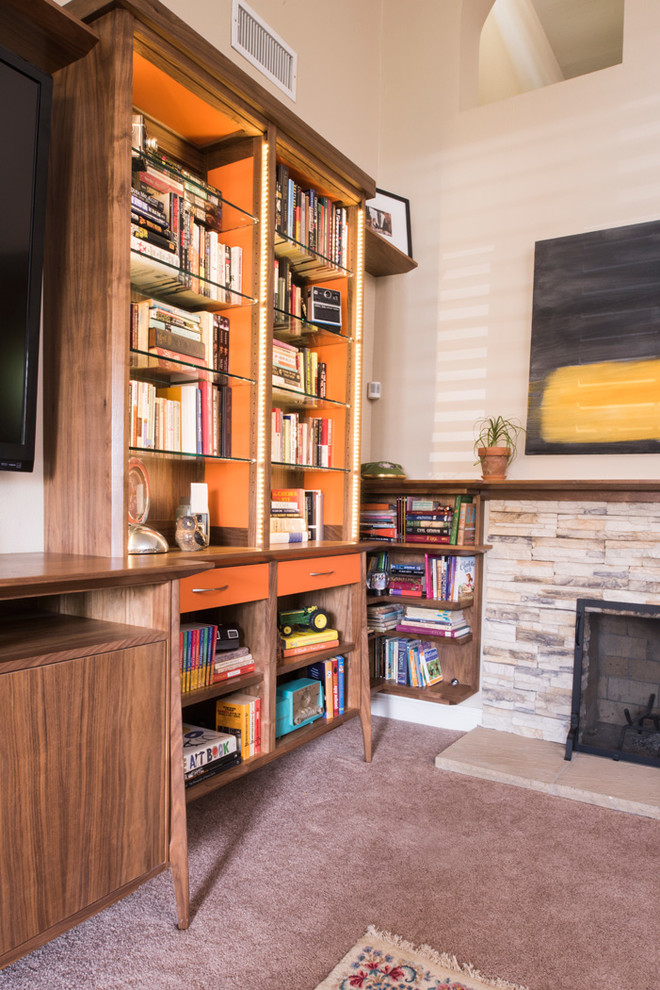 Living room library - large mid-century modern enclosed carpeted living room library idea in Los Angeles with beige walls, a standard fireplace, a stone fireplace and a media wall