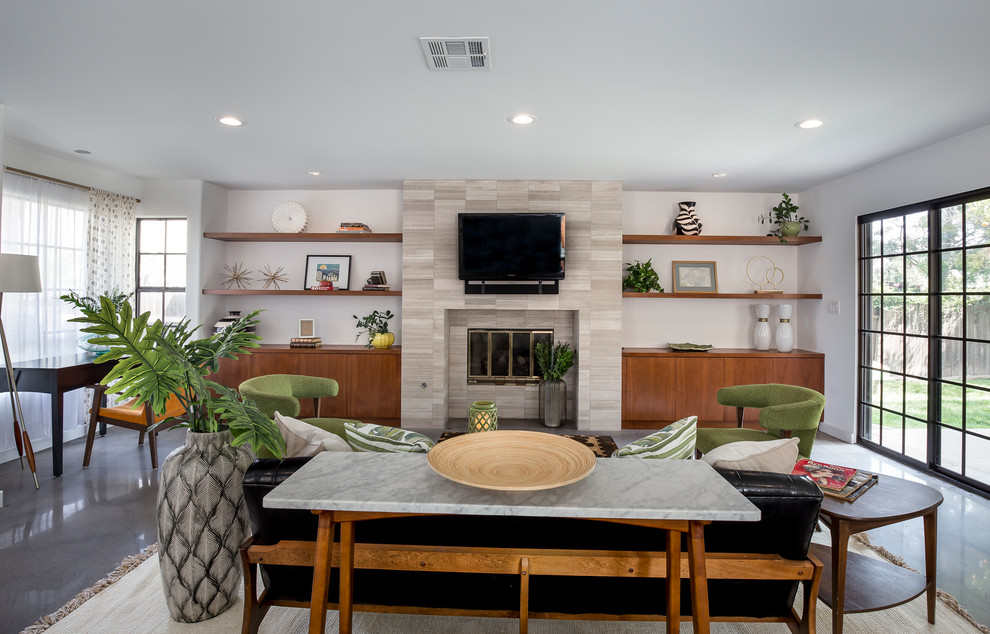 ロサンゼルスにある高級な広いミッドセンチュリースタイルのおしゃれなLDK (白い壁、コンクリートの床、標準型暖炉、壁掛け型テレビ、タイルの暖炉まわり、グレーの床) の写真