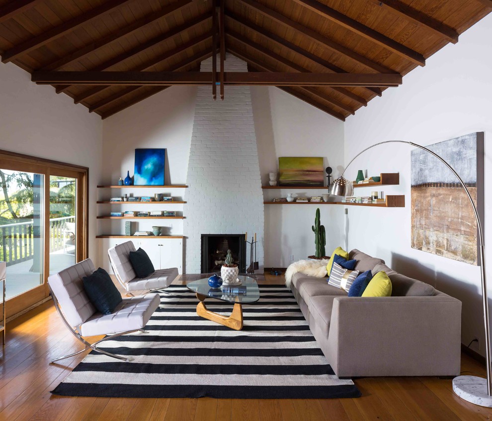 Foto di un soggiorno moderno aperto con pareti bianche, pavimento in legno massello medio, sala formale e camino classico
