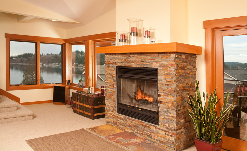 シアトルにある高級な広いトラディショナルスタイルのおしゃれなリビング (ベージュの壁、カーペット敷き、標準型暖炉、石材の暖炉まわり、テレビなし) の写真