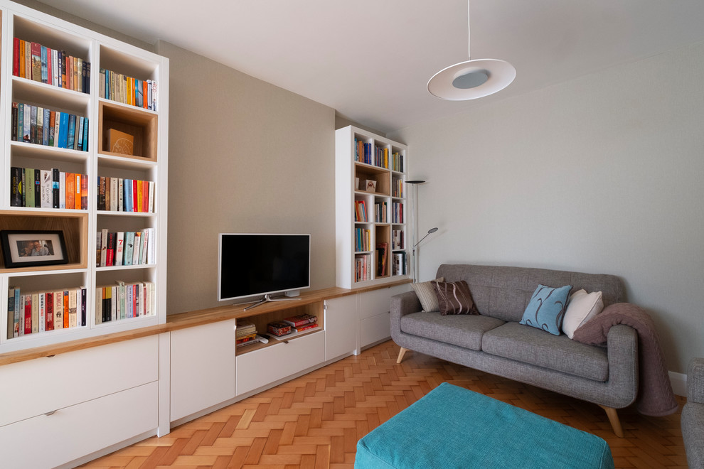 Aménagement d'un petit salon rétro ouvert avec un mur beige, parquet clair, un téléviseur indépendant, un sol beige et éclairage.