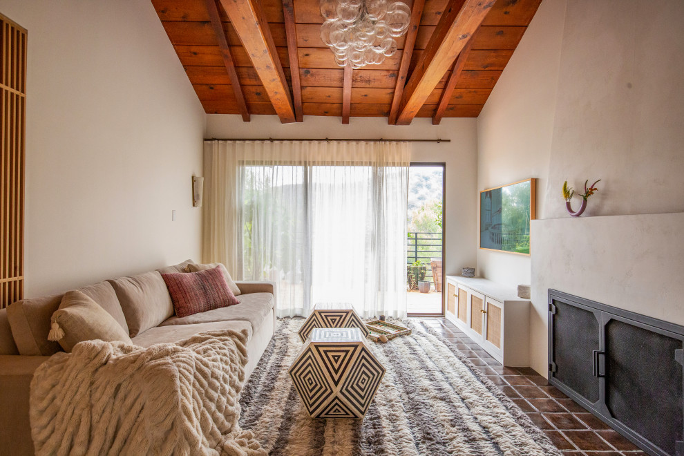 Immagine di un soggiorno minimalista chiuso con pareti bianche, camino classico, cornice del camino in intonaco, TV a parete e travi a vista