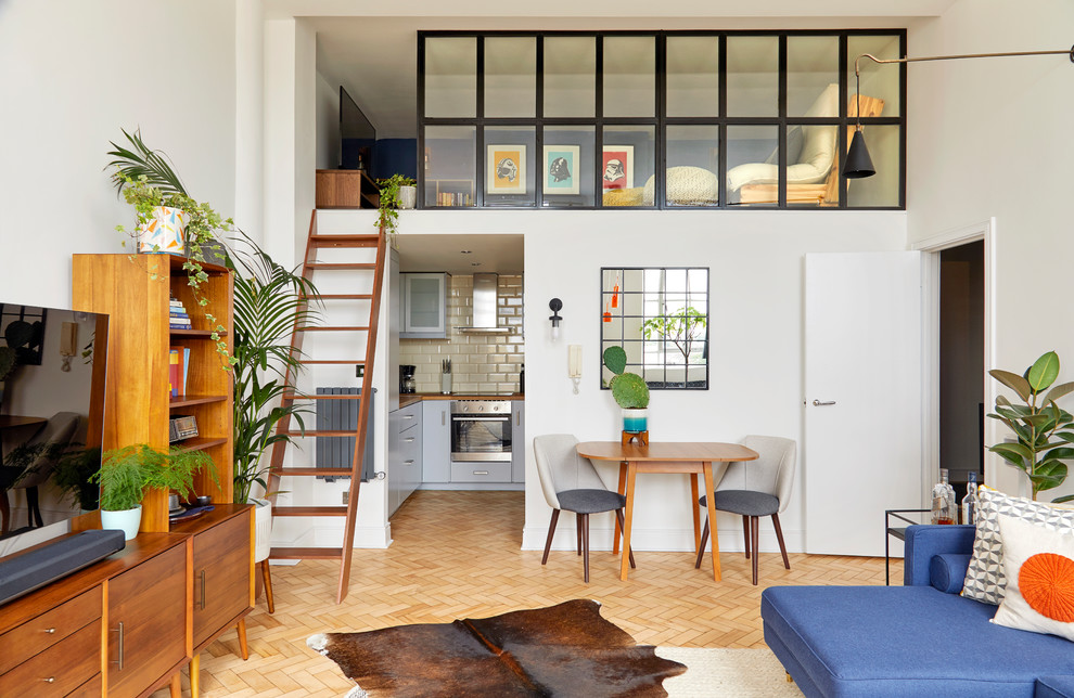 Kleines Retro Wohnzimmer ohne Kamin, im Loft-Stil mit weißer Wandfarbe, hellem Holzboden, freistehendem TV und beigem Boden in London