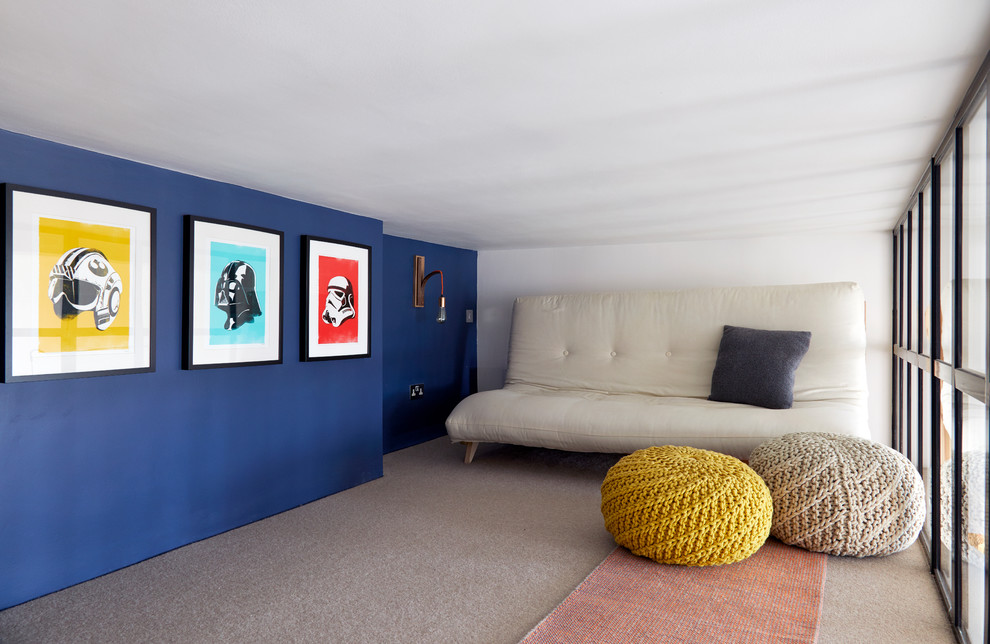 ロンドンにあるお手頃価格の小さなミッドセンチュリースタイルのおしゃれなリビングロフト (ライブラリー、青い壁、カーペット敷き、暖炉なし、据え置き型テレビ、ベージュの床) の写真