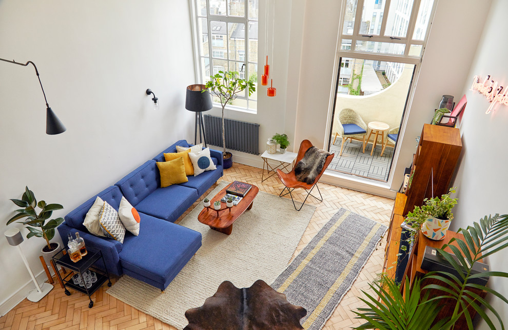 Immagine di un soggiorno moderno di medie dimensioni e stile loft con pareti bianche, parquet chiaro, TV a parete e pavimento beige