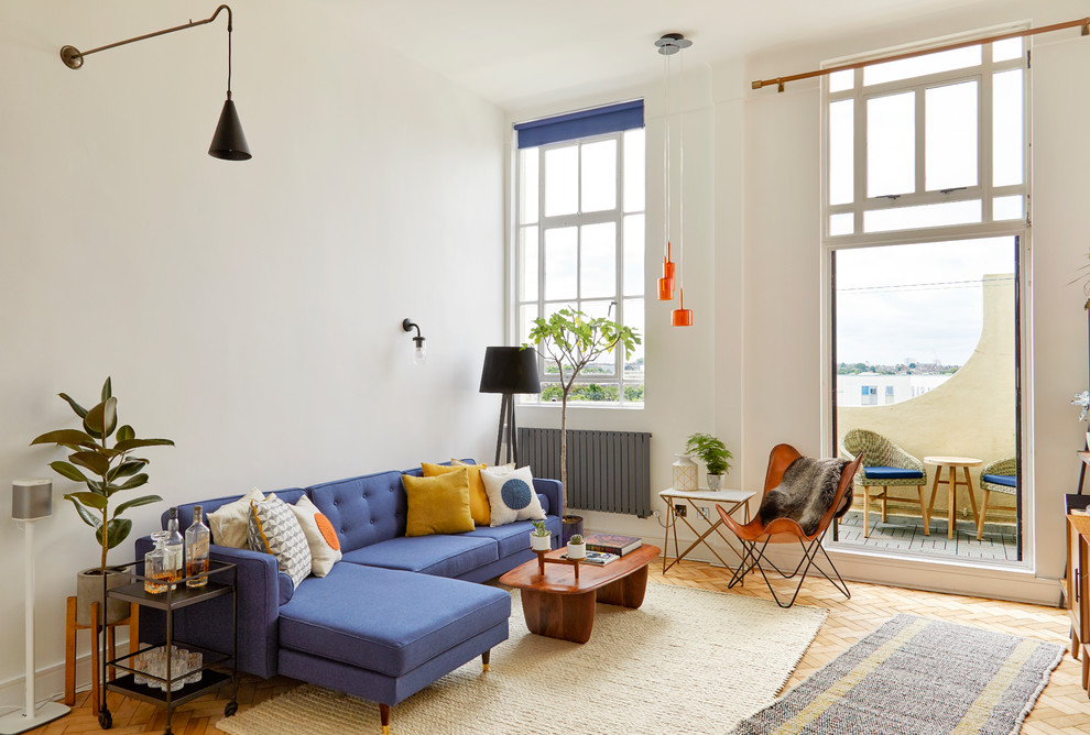 Immagine di un piccolo soggiorno moderno stile loft con pareti bianche, parquet chiaro, nessun camino, TV autoportante e pavimento beige