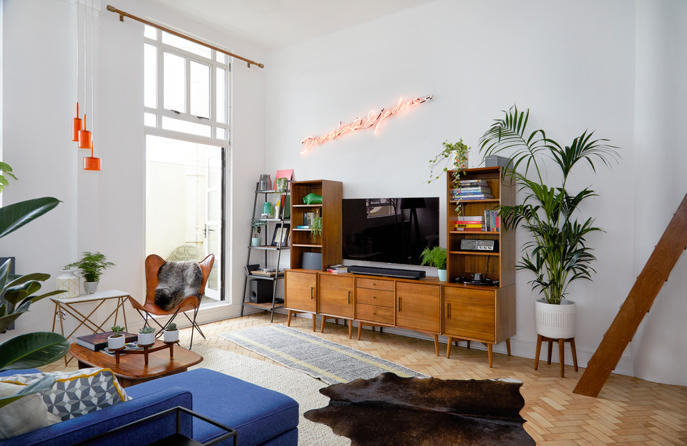 На фото: изолированная гостиная комната среднего размера в стиле ретро с белыми стенами, телевизором на стене и бежевым полом