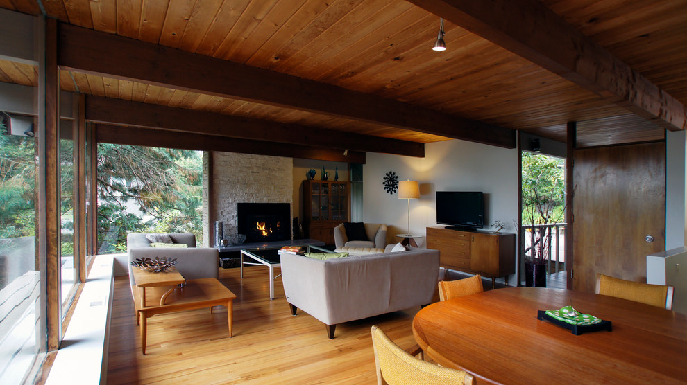 Mid-sized mid-century modern open concept and formal light wood floor living room photo in Seattle with a standard fireplace, a tv stand, beige walls and a stone fireplace