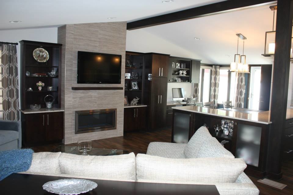 Стильный дизайн: большая открытая гостиная комната в стиле модернизм с серыми стенами, темным паркетным полом, стандартным камином, фасадом камина из плитки и телевизором на стене - последний тренд