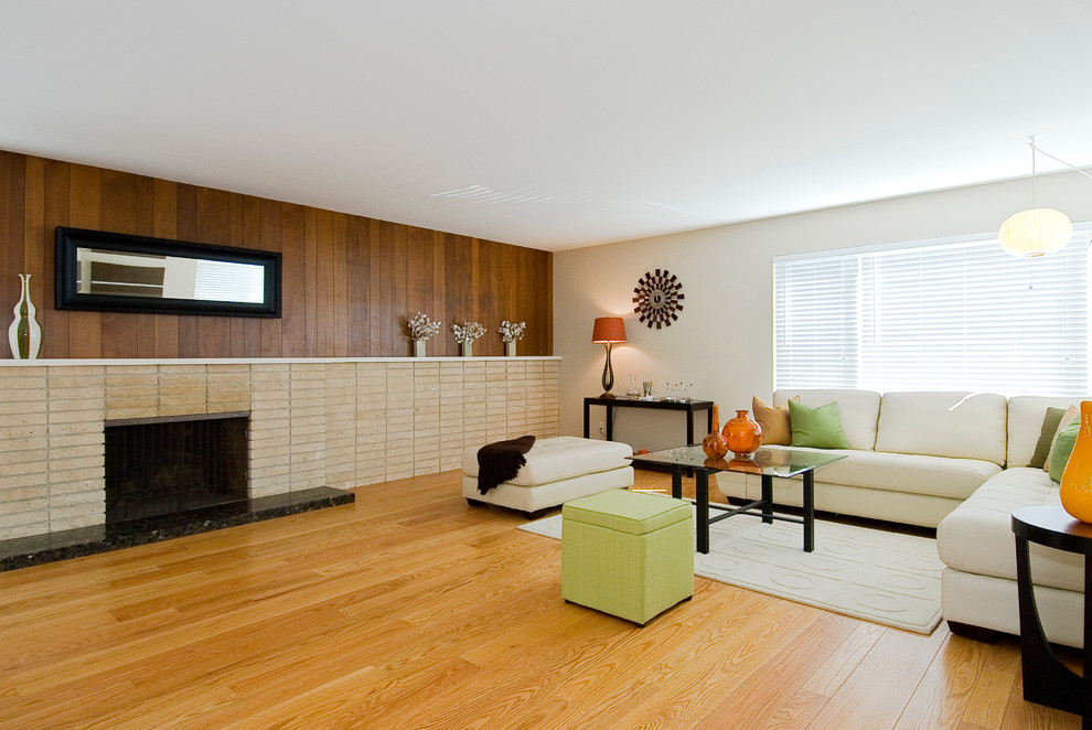 Example of a 1950s open concept light wood floor living room design in San Francisco with beige walls, a standard fireplace and a brick fireplace