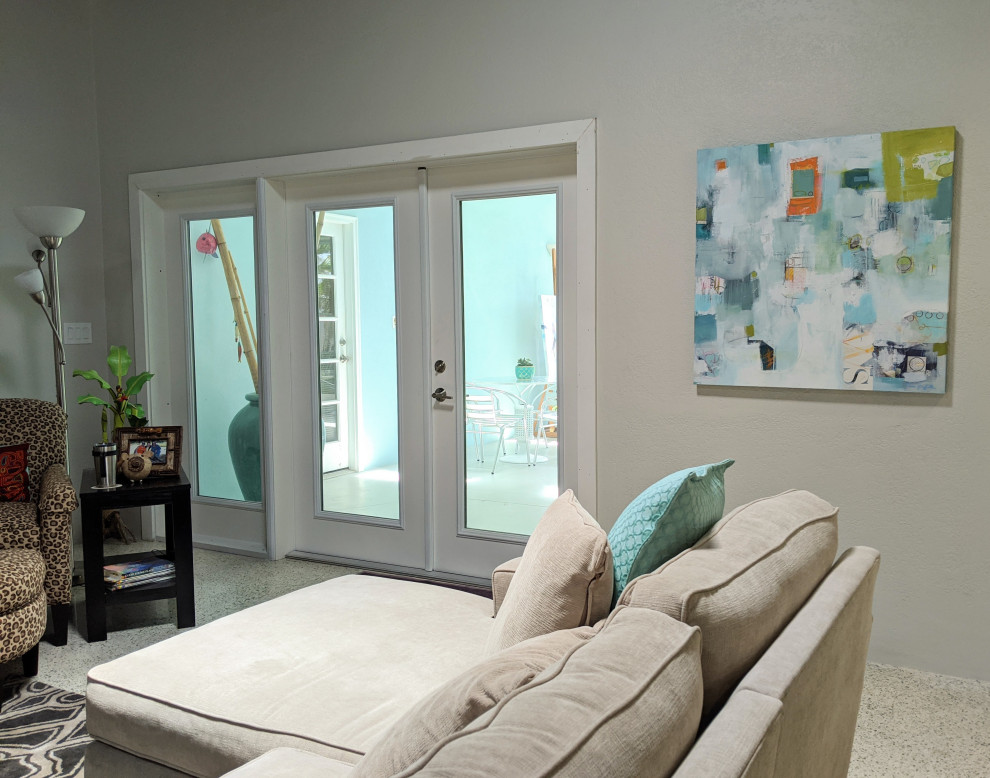 Foto di un grande soggiorno moderno aperto con pareti grigie, TV nascosta, pavimento grigio e soffitto a volta