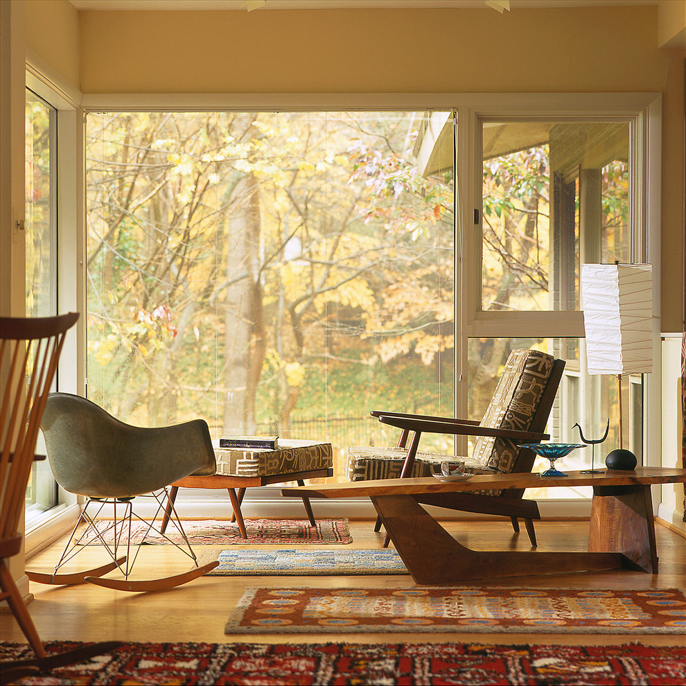 Diseño de salón retro con paredes beige, suelo de madera en tonos medios y alfombra