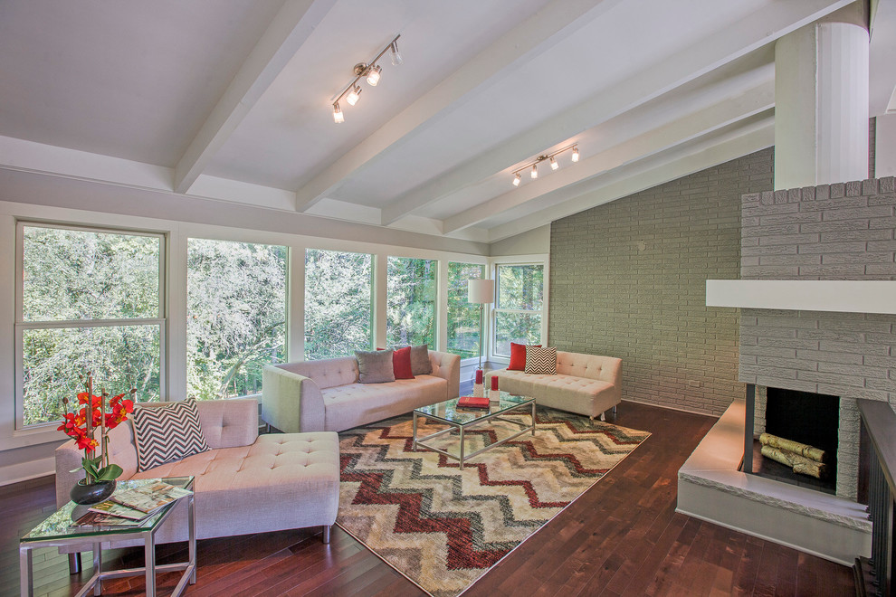 Living room - 1950s open concept dark wood floor living room idea in Grand Rapids with gray walls and a brick fireplace
