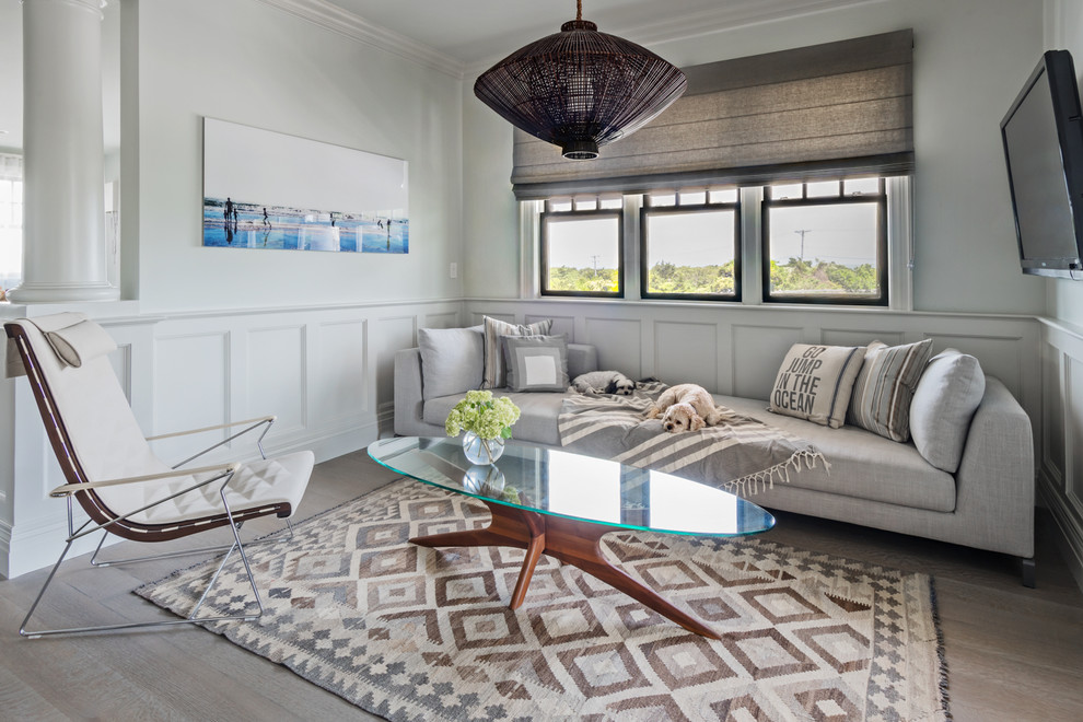 This is an example of a classic living room in Boston with grey walls, a wall mounted tv and grey floors.