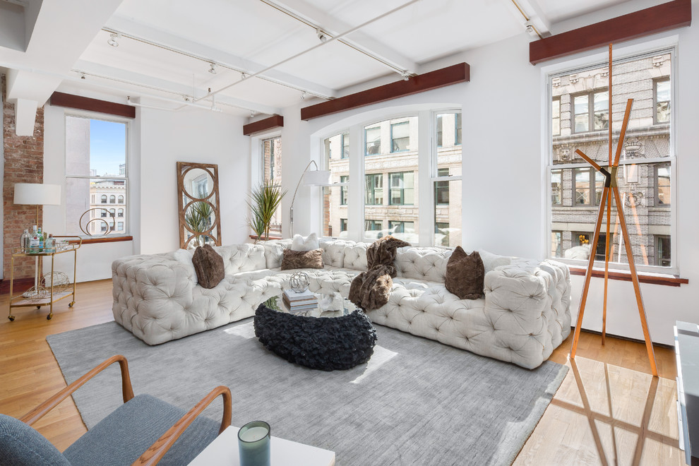 Large classic mezzanine living room in New York with white walls and medium hardwood flooring.