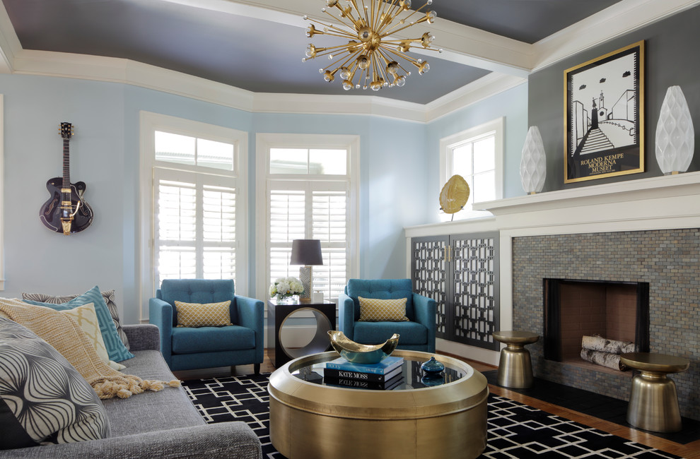 Réalisation d'un grand salon gris et noir tradition fermé avec un mur bleu, un sol en bois brun, une cheminée standard, un manteau de cheminée en carrelage, une salle de réception et éclairage.