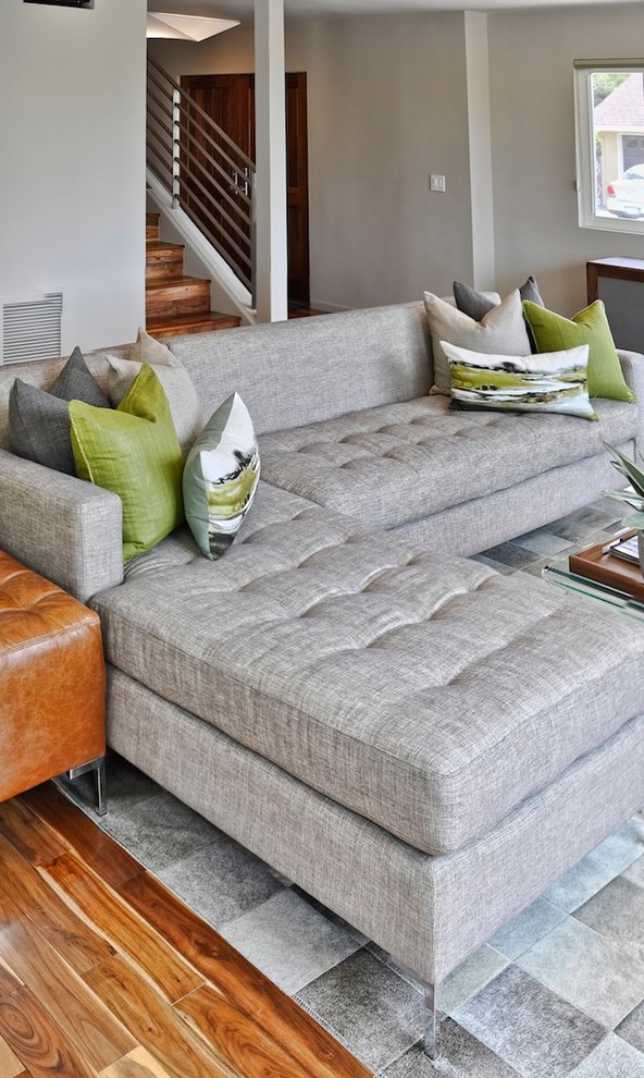 Example of a mid-sized 1960s open concept medium tone wood floor living room design in Los Angeles with gray walls and a concealed tv