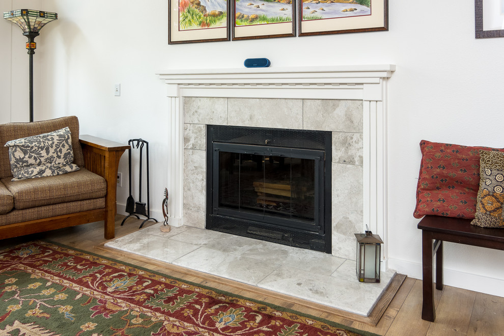 Example of a large transitional formal and loft-style medium tone wood floor and brown floor living room design in Portland with white walls, a standard fireplace, a tile fireplace and a tv stand