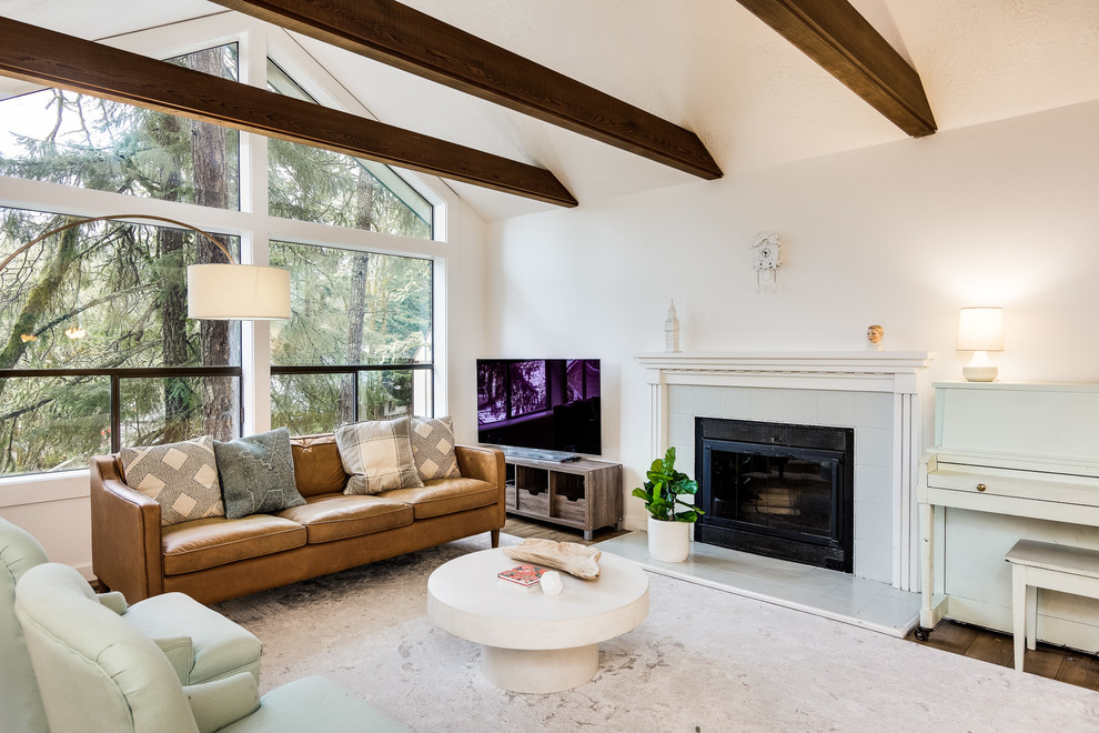 Large classic formal mezzanine living room in Portland with white walls, medium hardwood flooring, a freestanding tv, brown floors, a standard fireplace and a tiled fireplace surround.