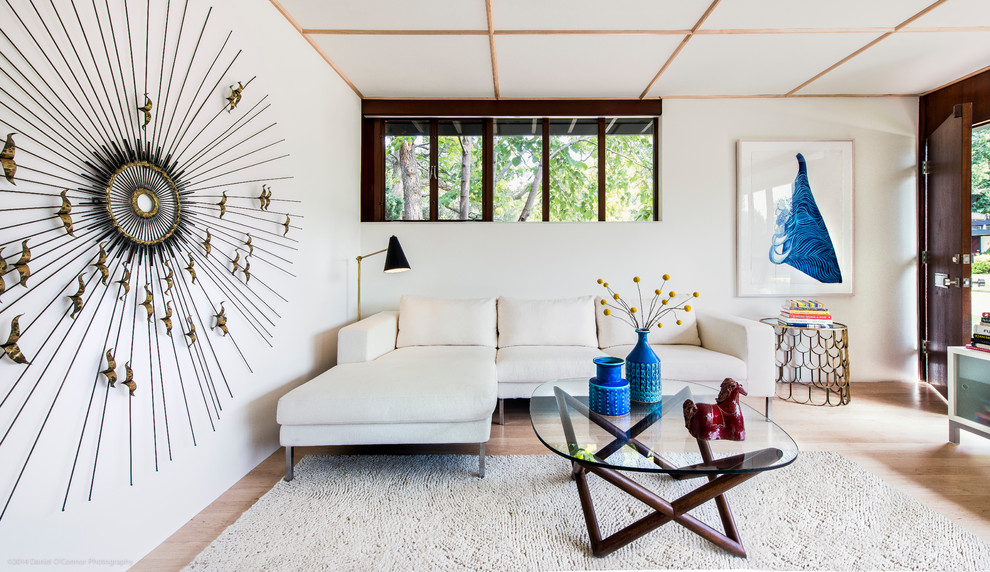 Стильный дизайн: маленькая открытая гостиная комната в стиле ретро с белыми стенами, светлым паркетным полом, фасадом камина из камня, телевизором на стене и стандартным камином для на участке и в саду - последний тренд