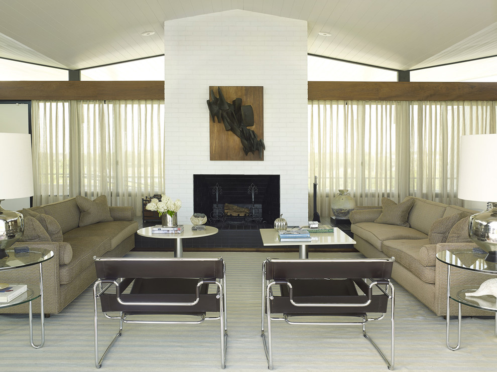 This is an example of a midcentury formal living room in New York with a standard fireplace and a brick fireplace surround.