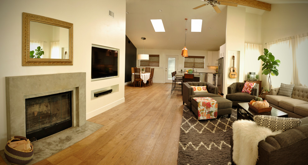 Inspiration for a large retro open plan living room in San Diego with white walls, light hardwood flooring, a concrete fireplace surround, a built-in media unit, a standard fireplace and brown floors.