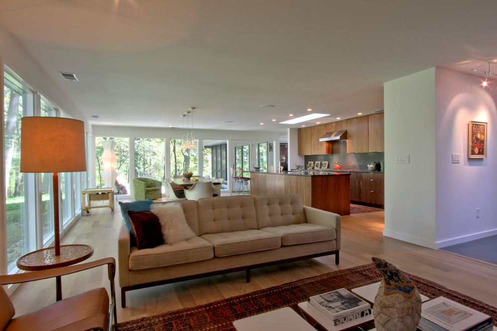 Ejemplo de salón abierto retro de tamaño medio sin televisor con paredes blancas, suelo de madera clara y suelo beige