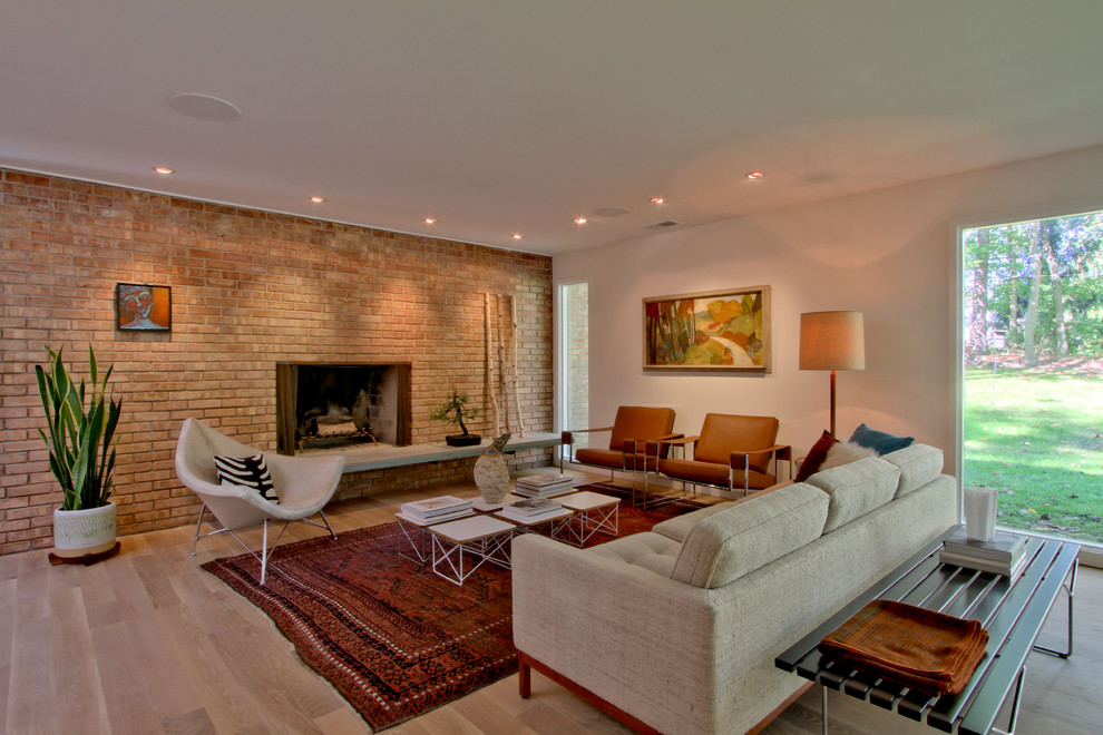 Medium sized midcentury formal open plan living room in Indianapolis with white walls, light hardwood flooring, a standard fireplace, a brick fireplace surround, no tv and beige floors.