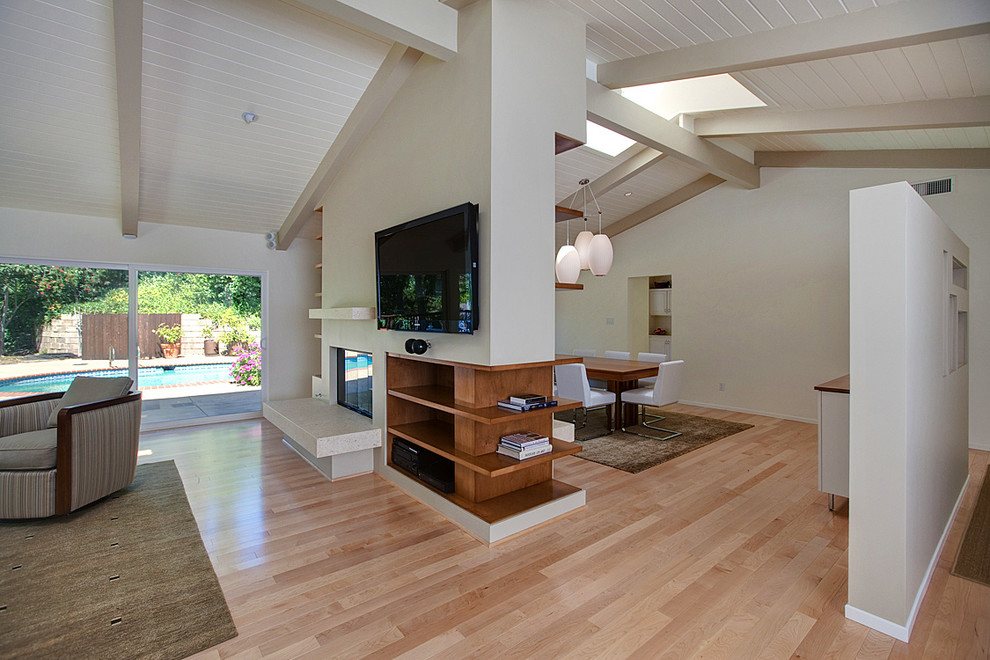 Mid-sized mid-century modern formal and open concept light wood floor living room photo in Los Angeles with beige walls, a two-sided fireplace and a wall-mounted tv