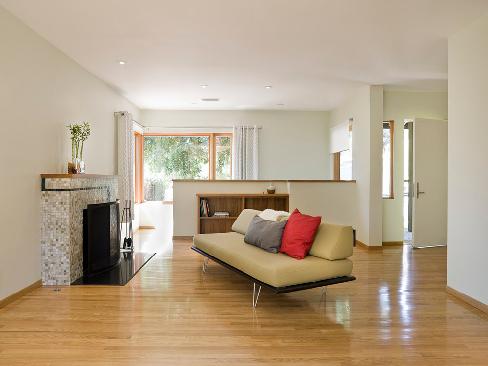 Inspiration for a mid-sized modern formal and enclosed medium tone wood floor and beige floor living room remodel in Portland with white walls, a standard fireplace, a tile fireplace and no tv