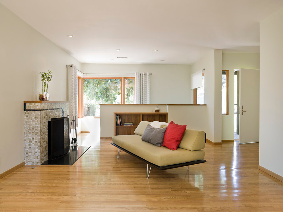 Mittelgroßes, Repräsentatives, Fernseherloses, Abgetrenntes Modernes Wohnzimmer mit weißer Wandfarbe, braunem Holzboden, Kamin, gefliester Kaminumrandung und beigem Boden in Portland