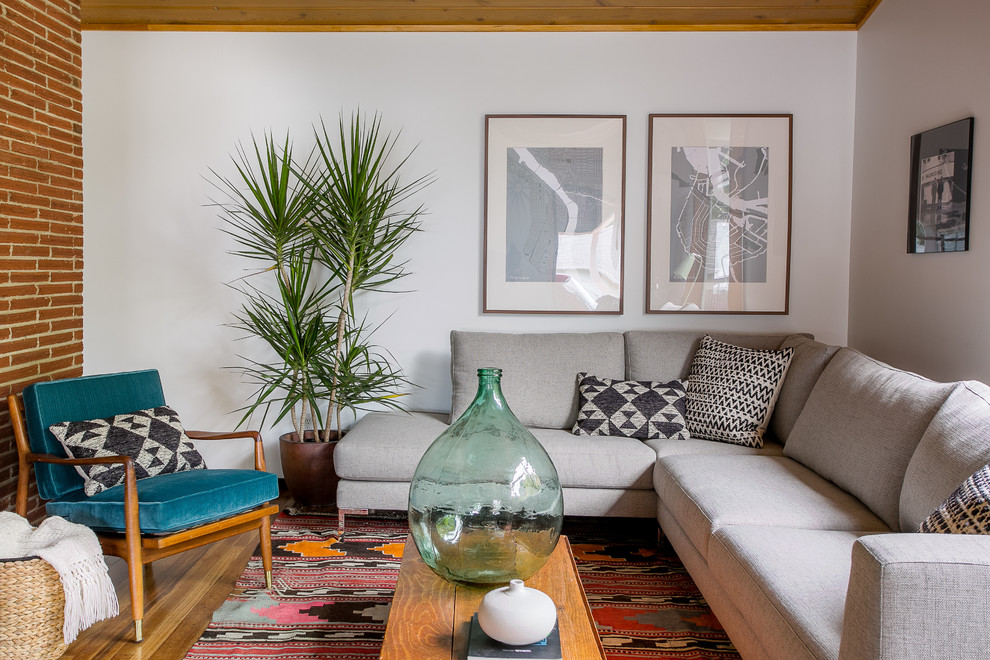 Esempio di un soggiorno moderno con pareti bianche, pavimento in legno massello medio e tappeto