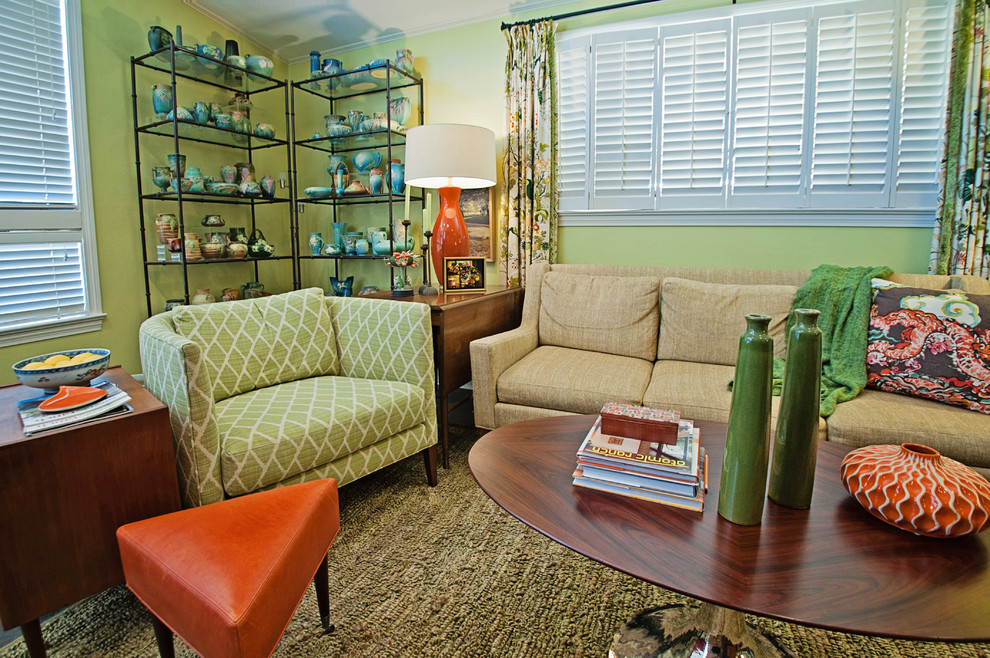 Mittelgroßes, Offenes Mid-Century Wohnzimmer mit grüner Wandfarbe, Betonboden, Kamin, Kaminumrandung aus Backstein und freistehendem TV in New Orleans