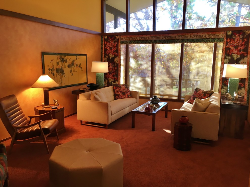 Foto de salón cerrado retro de tamaño medio sin televisor con parades naranjas, moqueta, todas las chimeneas, marco de chimenea de ladrillo y suelo naranja