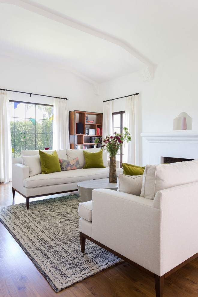 Cette photo montre un salon moderne avec une salle de réception, un mur blanc, un sol en bois brun, une cheminée standard et un sol marron.
