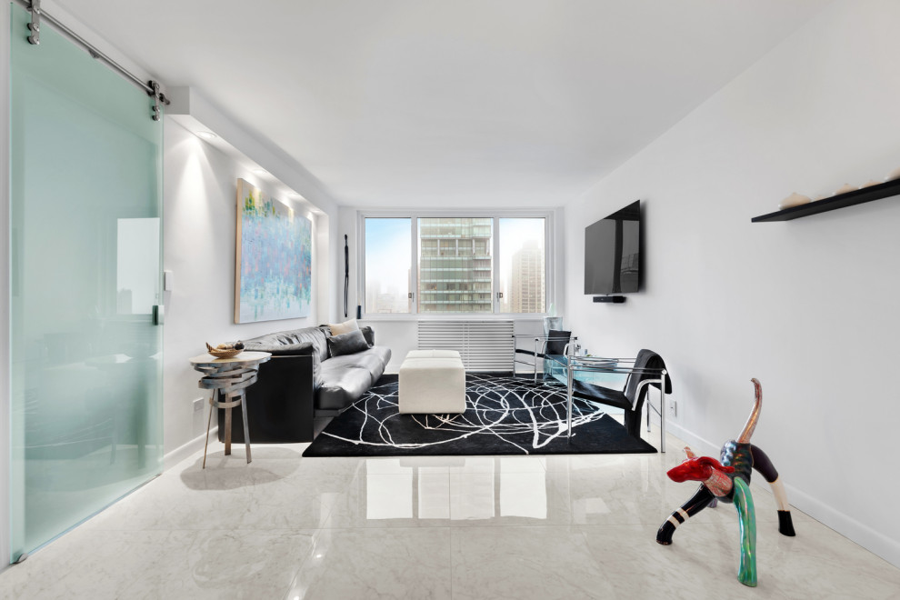Esempio di un soggiorno design con pareti bianche, TV a parete e pavimento grigio