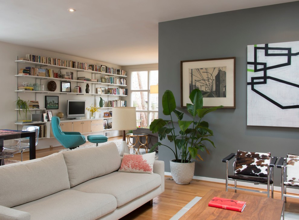 Idee per un grande soggiorno minimalista aperto con libreria, pareti bianche, parquet chiaro, nessun camino e TV autoportante