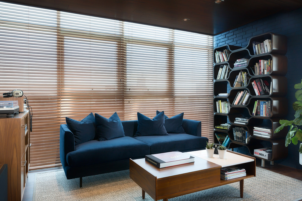 Immagine di un soggiorno moderno di medie dimensioni e stile loft con pareti blu, pavimento in laminato, nessun camino, cornice del camino in mattoni, nessuna TV e pavimento marrone