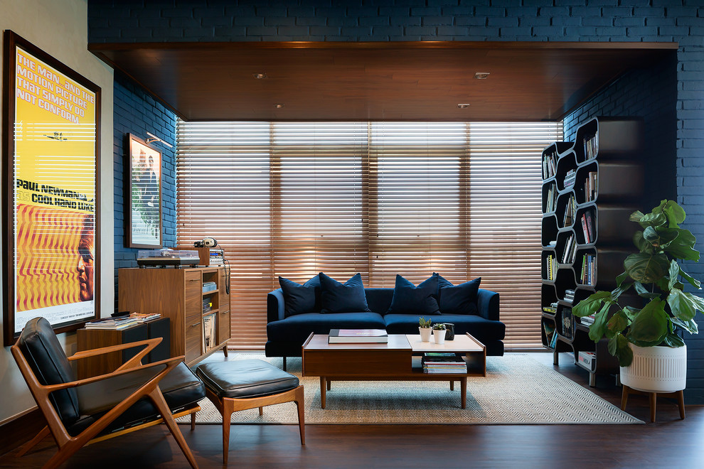 Mittelgroßes, Fernseherloses Retro Musikzimmer ohne Kamin, im Loft-Stil mit blauer Wandfarbe, Laminat und braunem Boden in Sonstige