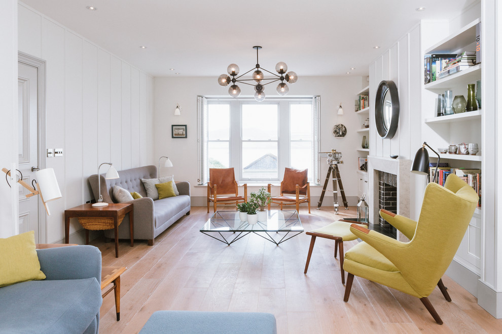 Fernseherloses, Abgetrenntes, Mittelgroßes Retro Wohnzimmer mit weißer Wandfarbe, hellem Holzboden, Kamin und Kaminumrandung aus Backstein in Cornwall