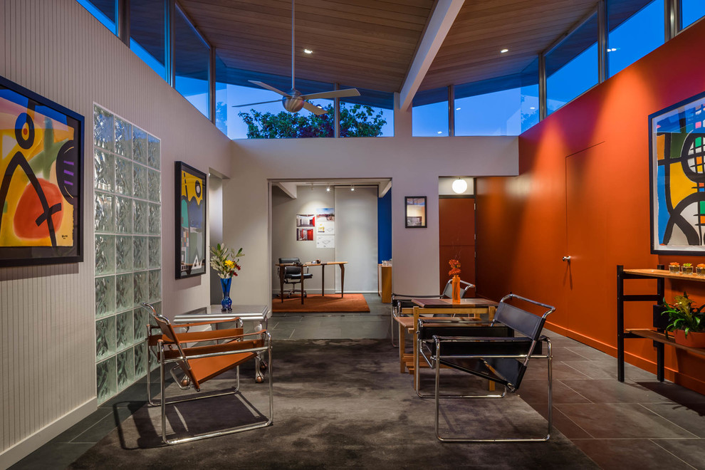 Immagine di un soggiorno moderno aperto con pareti arancioni e pavimento grigio