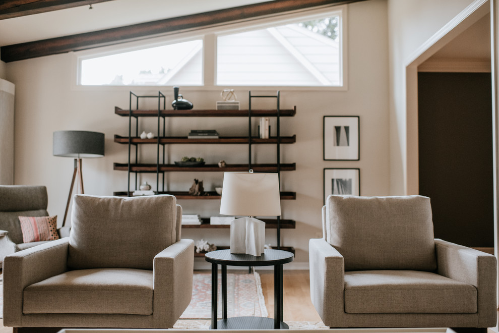 Immagine di un soggiorno moderno aperto con pareti beige e parquet chiaro