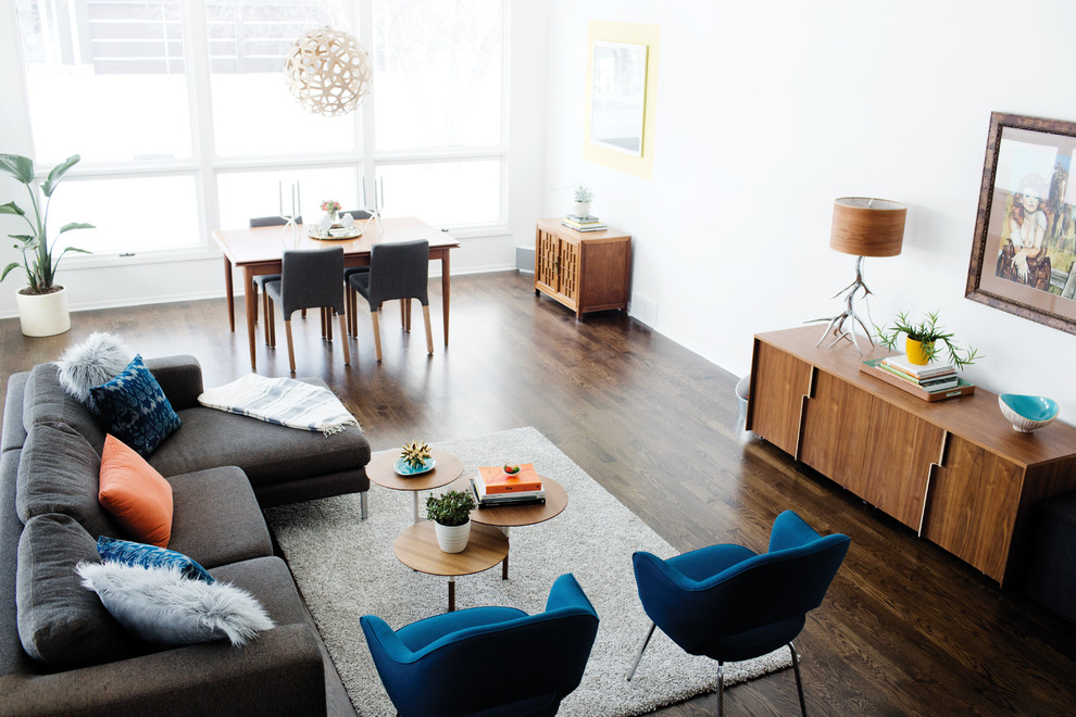 Photo of a large midcentury open plan living room in Minneapolis with white walls, dark hardwood flooring, no fireplace and no tv.
