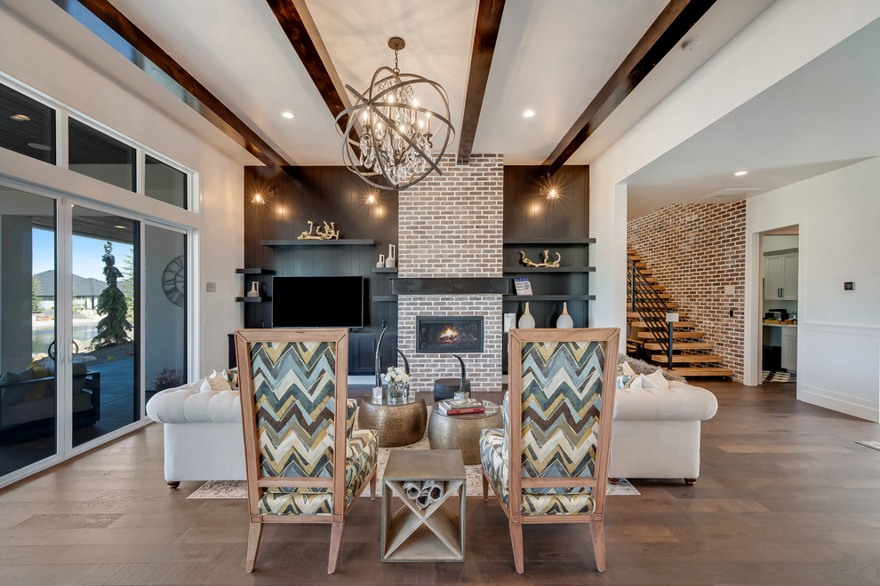 Expansive traditional open plan living room in Boise with medium hardwood flooring, a ribbon fireplace, brown floors, white walls, a brick fireplace surround and a freestanding tv.