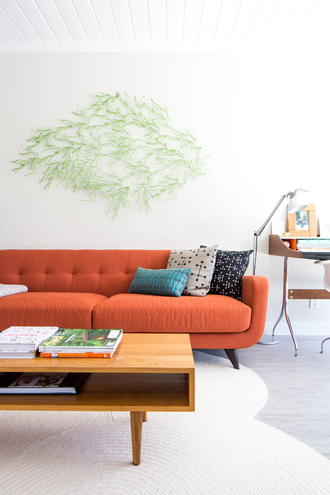 This is an example of a midcentury open plan living room in San Francisco with white walls and grey floors.