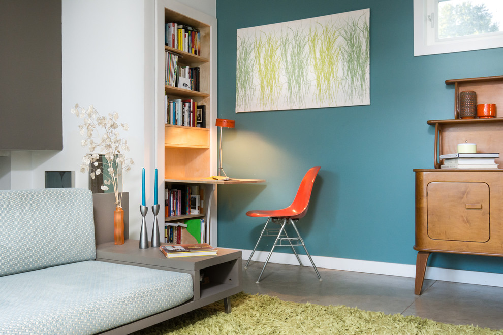 Esempio di un piccolo soggiorno moderno aperto con pareti blu, pavimento in cemento, camino classico, cornice del camino in metallo e nessuna TV
